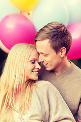 Image showing couple with colorful balloons kissing in the park