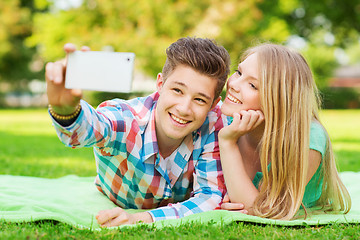 Image showing smiling couple making selfie in park