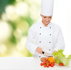 Image showing smiling female chef chopping vegetables