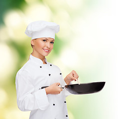 Image showing smiling female chef with pan and spoon