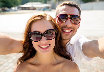 Image showing smiling couple wearing sunglasses making selfie