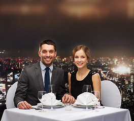 Image showing smiling couple holding hands at restaurant