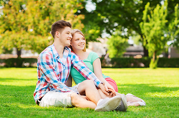Image showing smiling couple sitting on grass in park