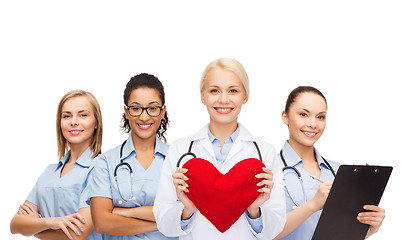 Image showing smiling female doctor and nurses with red heart