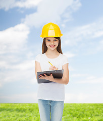 Image showing smiling little girl in hardhat with clipboard