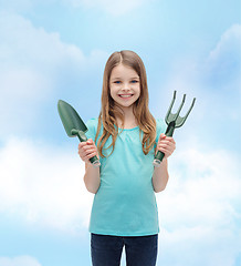 Image showing smiling little girl with rake and scoop