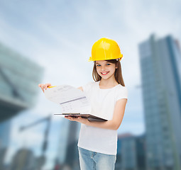 Image showing smiling little girl in hardhat with clipboard