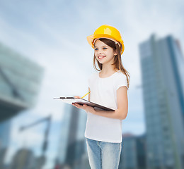 Image showing smiling little girl in hardhat with clipboard