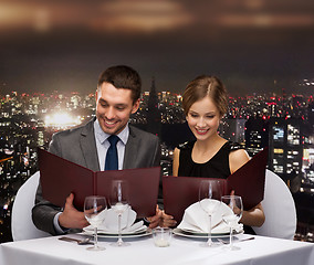 Image showing smiling couple with menus at restaurant