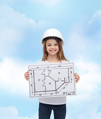 Image showing smiling little girl in helmet showing blueprint