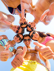 Image showing smiling friends showing thumbs up in circle