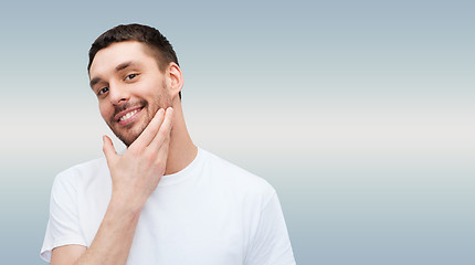 Image showing beautiful smiling man touching his face