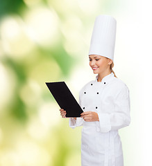 Image showing smiling female chef with black blank paper