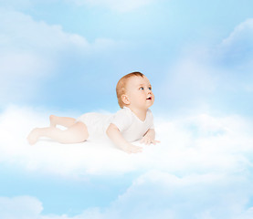 Image showing smiling baby lying on cloud and looking up