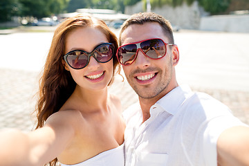 Image showing smiling couple wearing sunglasses making selfie