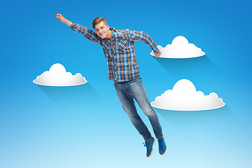 Image showing smiling young man jumping in air