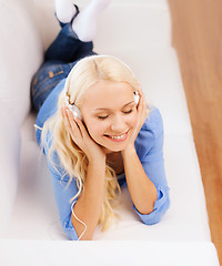 Image showing smiling young woman in headphones at home