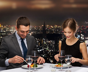 Image showing smiling couple eating main course at restaurant