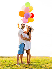 Image showing smiling couple with air balloons outdoors