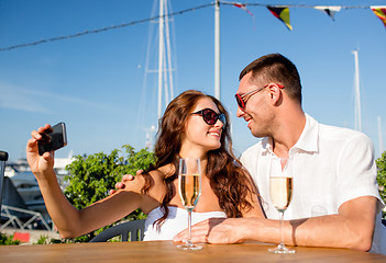 Image showing smiling couple drinking champagne at cafe