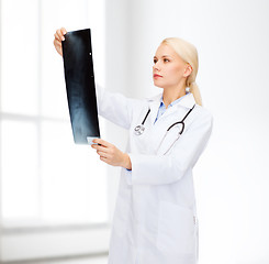 Image showing serious female doctor looking at x-ray