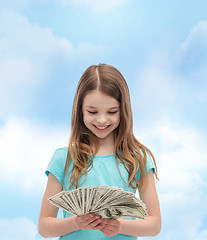 Image showing smiling little girl looking at dollar cash money