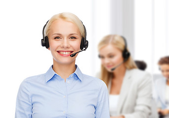 Image showing friendly female helpline operator with headphones