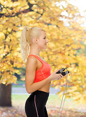 Image showing smiling sporty woman with skipping rope