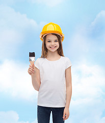 Image showing smiling little girl in helmet with paint roller