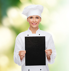 Image showing smiling female chef with black blank paper