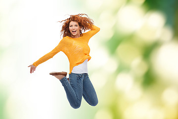 Image showing smiling young woman jumping in air