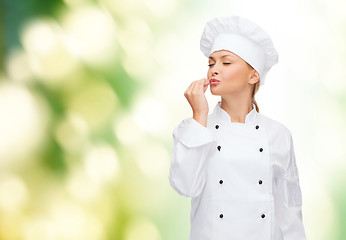 Image showing smiling female chef showing delicious sign