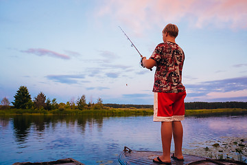 Image showing Belarusian Boy Fishing From Old Boats At Sunset Of A Summer Day