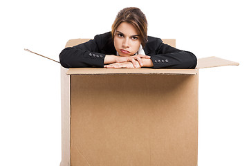 Image showing Stressed business woman inside a card box