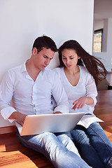 Image showing relaxed young couple working on laptop computer at home