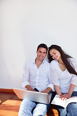 Image showing relaxed young couple working on laptop computer at home