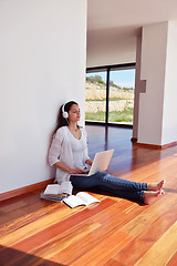 Image showing relaxed young woman at home working on laptop