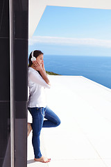 Image showing girl listening to the music on white headphones