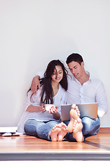 Image showing relaxed young couple working on laptop computer at home