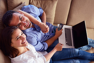 Image showing relaxed young couple working on laptop computer at home