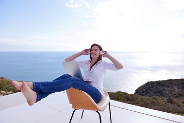 Image showing relaxed young woman at home working on laptop