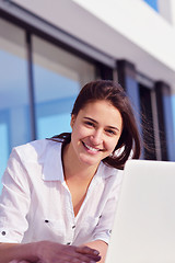 Image showing relaxed young woman at home working on laptop computer