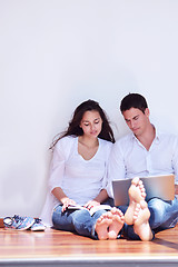 Image showing relaxed young couple working on laptop computer at home