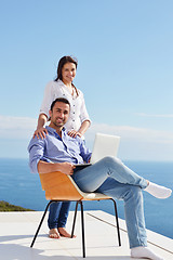 Image showing relaxed young couple working on laptop computer at home