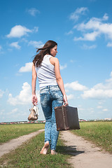 Image showing Pretty woman with old suitcase goes afar