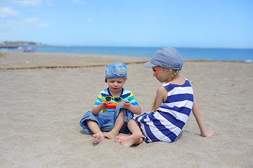 Image showing Two kids sitting on the beach