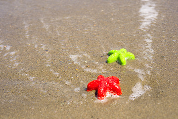 Image showing Two starfish-shaped molds on the sand