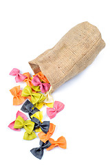 Image showing Multicolored farfalle falling from canvas bag