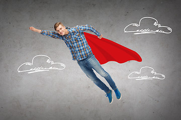 Image showing smiling young man jumping in air