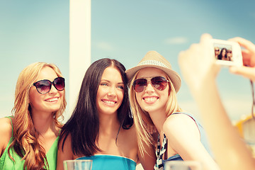 Image showing girls taking photo with digital camera in cafe